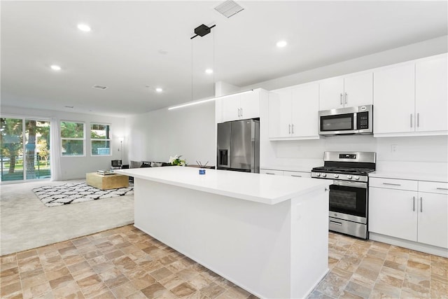 kitchen featuring white cabinetry, a center island, pendant lighting, and appliances with stainless steel finishes