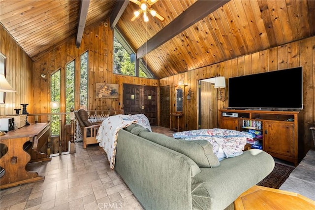 living area featuring stone tile floors, a ceiling fan, wooden ceiling, wooden walls, and beam ceiling