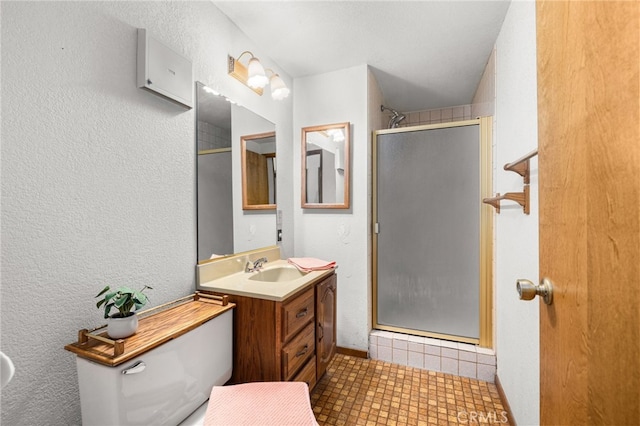 bathroom featuring vanity, a shower with shower door, and toilet