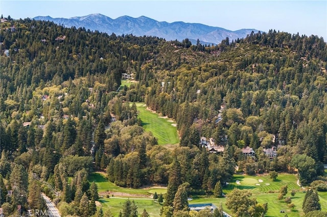 birds eye view of property with a mountain view, a view of trees, and golf course view