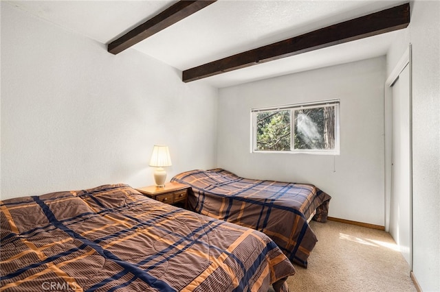 carpeted bedroom with beamed ceiling