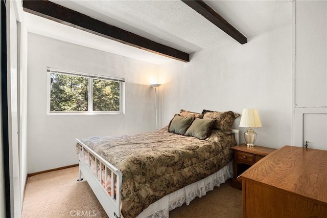 carpeted bedroom featuring beamed ceiling and baseboards