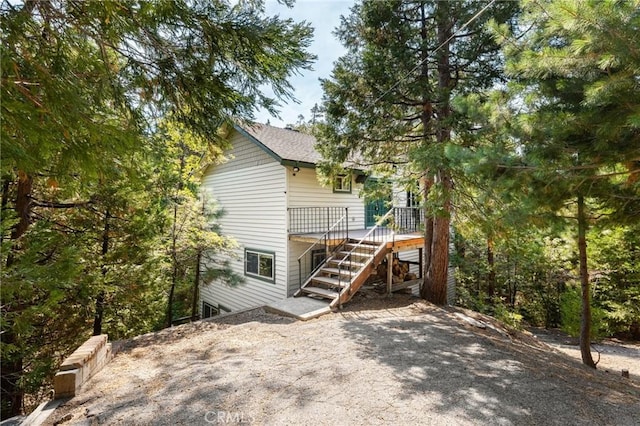 rear view of house featuring stairway and a deck