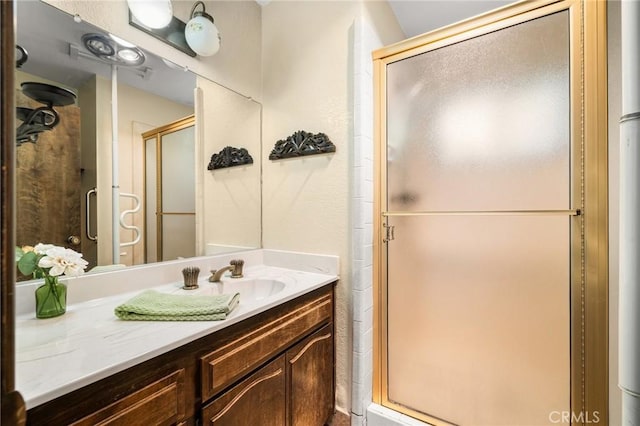 bathroom with a shower stall and vanity