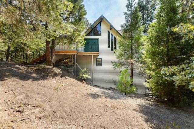 rear view of house with stairs and a wooden deck