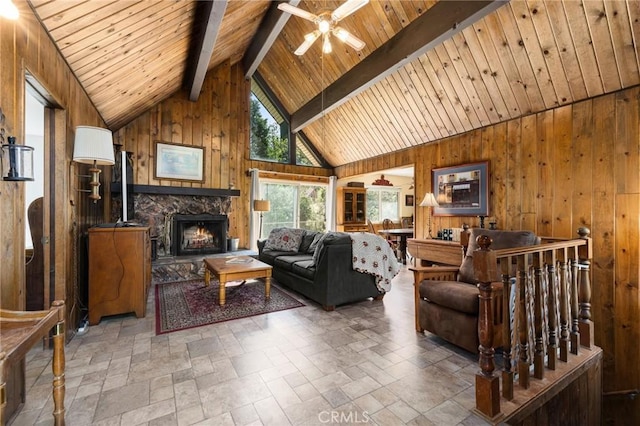 living area featuring wood walls, ceiling fan, wooden ceiling, and lofted ceiling with beams