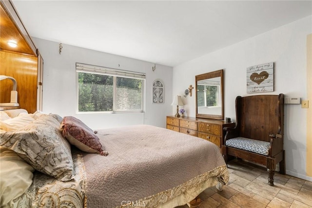 bedroom featuring baseboards and stone finish flooring