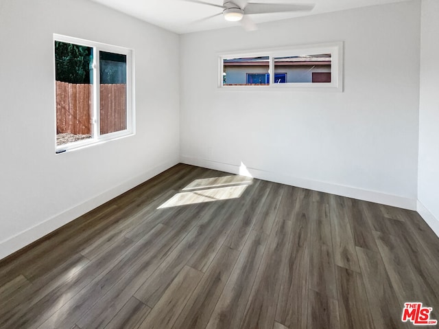 empty room with ceiling fan and dark hardwood / wood-style flooring