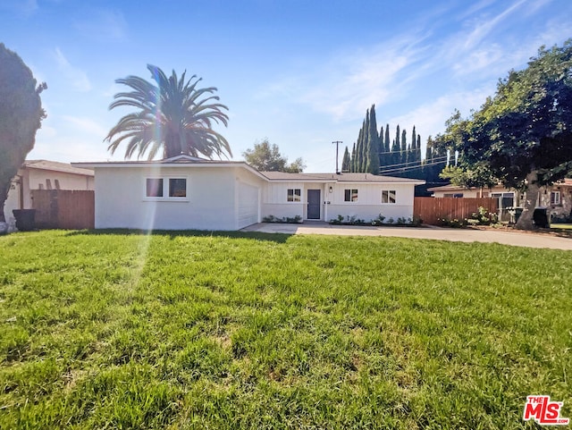 rear view of property featuring a lawn and a garage