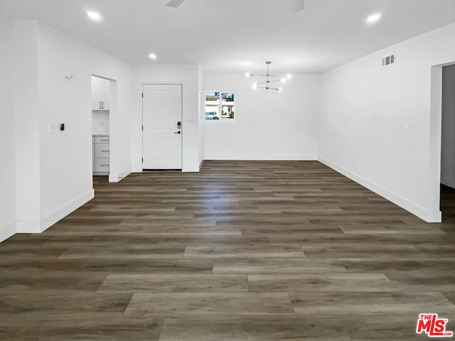 unfurnished room featuring dark hardwood / wood-style flooring and a chandelier