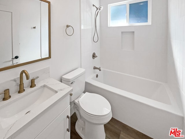 full bathroom with hardwood / wood-style floors, vanity, toilet, and tiled shower / bath