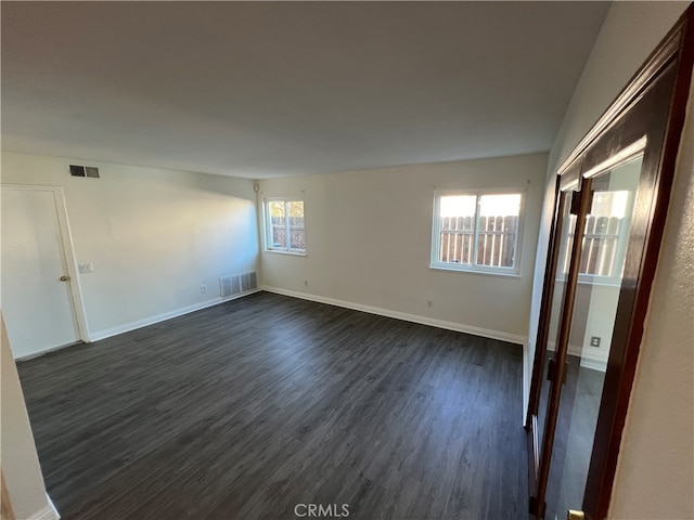 empty room featuring dark hardwood / wood-style floors and a wealth of natural light