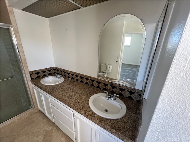 bathroom with vanity, a shower with shower door, toilet, and tile patterned flooring