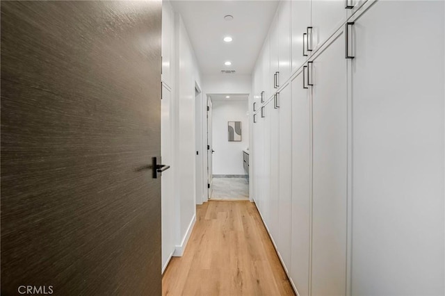 hallway featuring recessed lighting, light wood-type flooring, baseboards, and visible vents