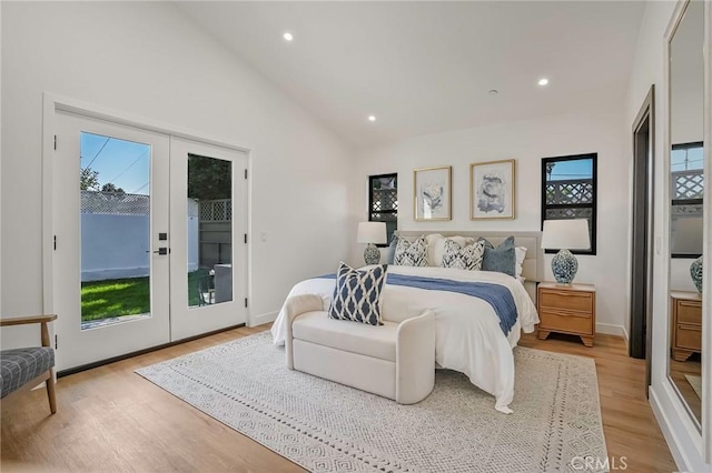 bedroom with light wood finished floors, multiple windows, french doors, and access to outside