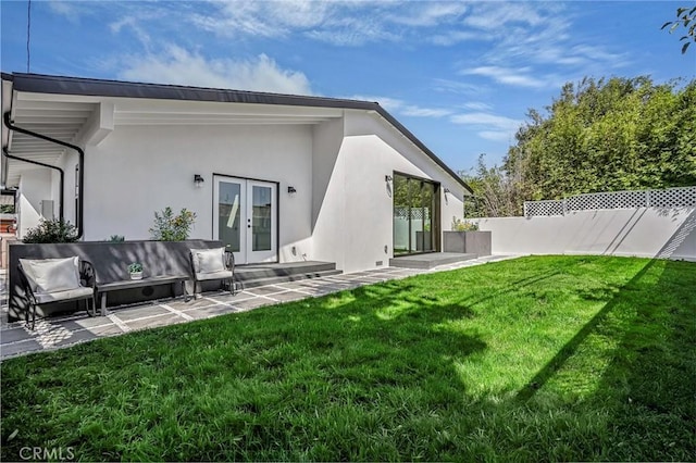 back of house featuring fence, stucco siding, a lawn, french doors, and a patio