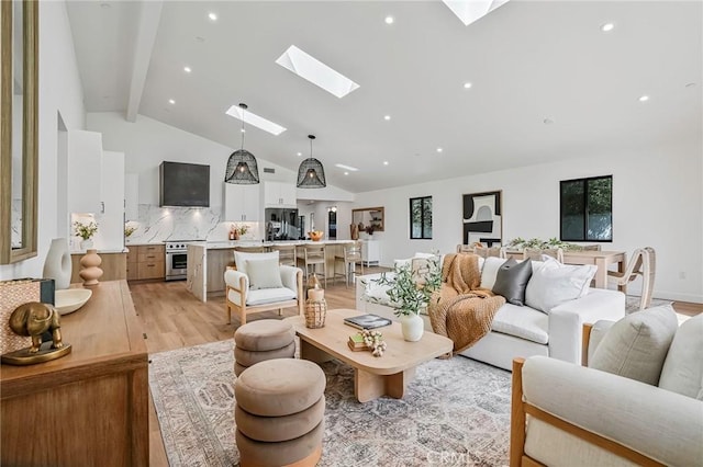 living room featuring vaulted ceiling with skylight and light hardwood / wood-style flooring