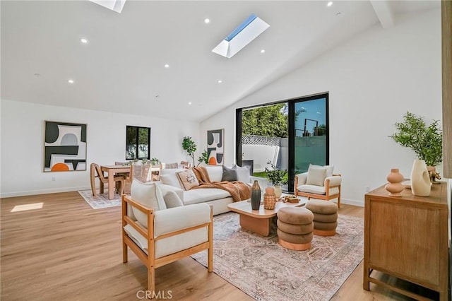 living area with baseboards, high vaulted ceiling, a skylight, recessed lighting, and light wood-style floors