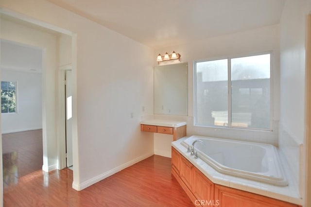 bathroom featuring hardwood / wood-style floors and a tub to relax in