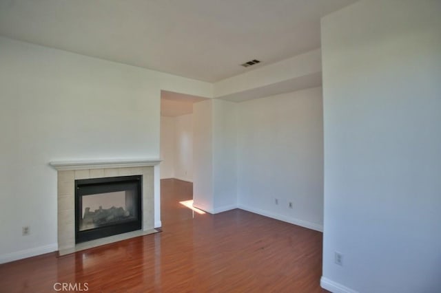 unfurnished living room with a fireplace and dark hardwood / wood-style floors