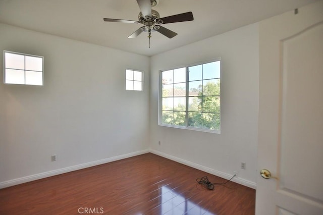 spare room featuring ceiling fan and dark wood-type flooring