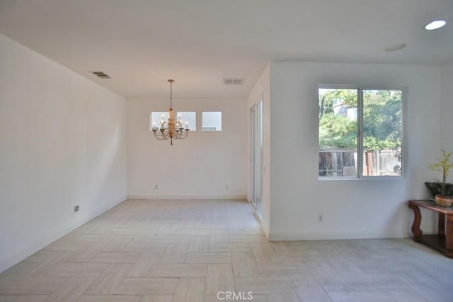 unfurnished room with a notable chandelier