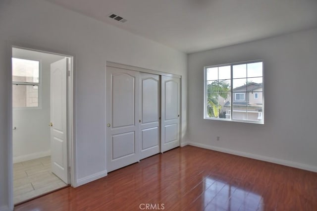 unfurnished bedroom featuring a closet and light wood-type flooring