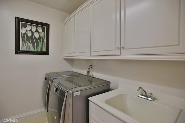 clothes washing area featuring cabinets, sink, and washing machine and clothes dryer