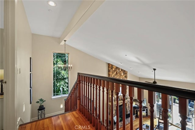 corridor with lofted ceiling with beams, plenty of natural light, hardwood / wood-style floors, and a notable chandelier