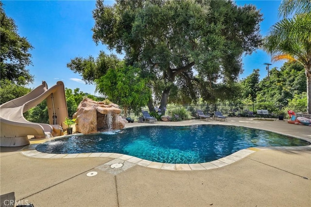 view of pool featuring a patio, a water slide, and pool water feature