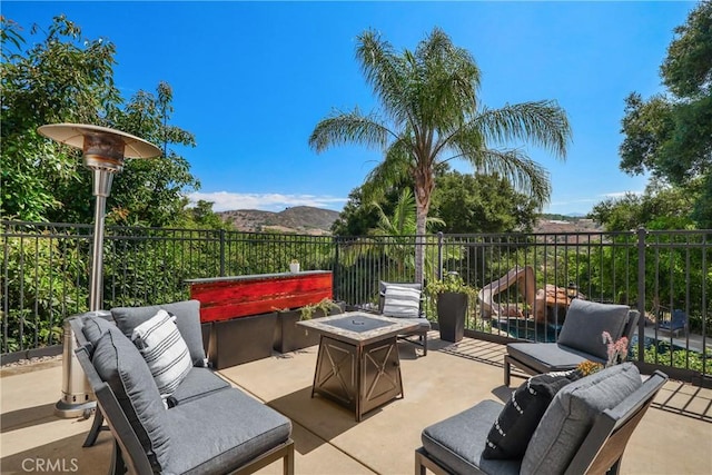 view of patio with a mountain view and an outdoor living space with a fire pit