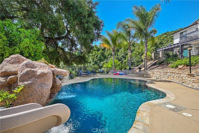 view of swimming pool with a patio and pool water feature