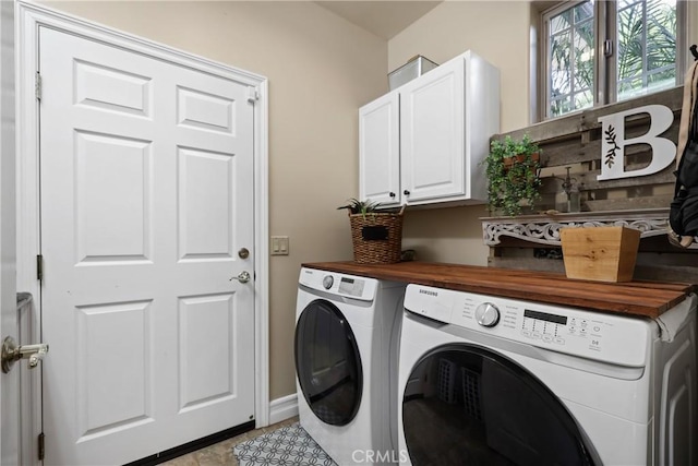 clothes washing area with cabinets, independent washer and dryer, and light tile patterned floors