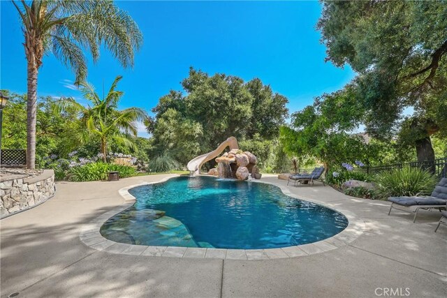 view of swimming pool featuring a patio and a water slide