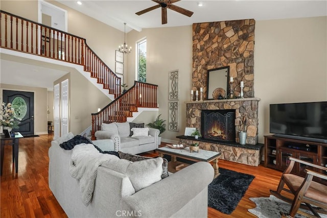 living room with hardwood / wood-style flooring, high vaulted ceiling, a fireplace, and beam ceiling