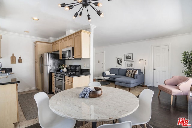 dining room with ornamental molding, light hardwood / wood-style floors, a notable chandelier, and sink