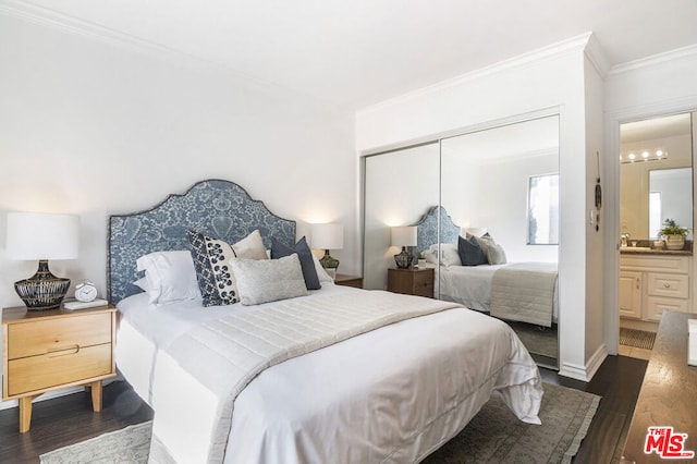 bedroom with ensuite bathroom, ornamental molding, sink, dark hardwood / wood-style floors, and a closet