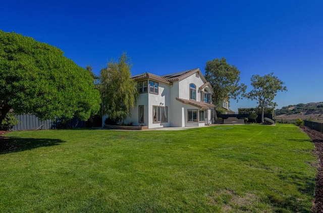 back of house with a yard and a patio