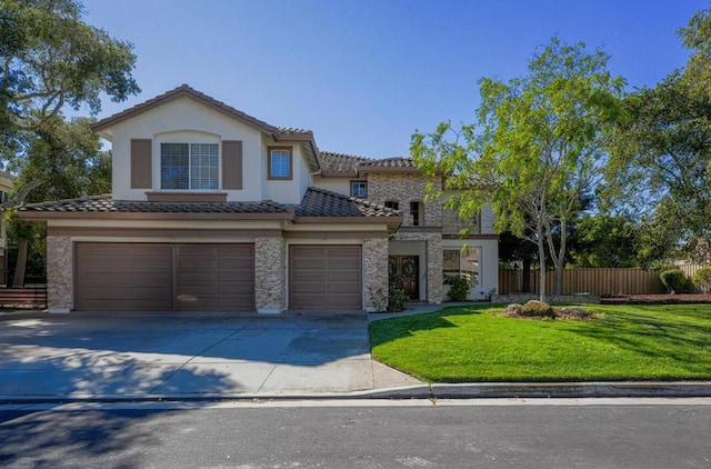 mediterranean / spanish house featuring a garage and a front lawn