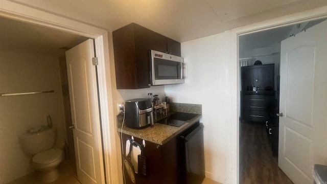 kitchen with dark brown cabinets, dark wood-type flooring, and stainless steel appliances