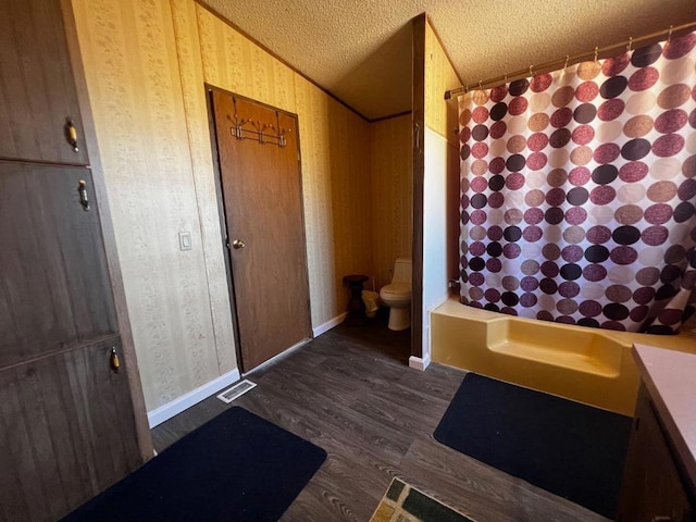 full bathroom with toilet, hardwood / wood-style floors, vaulted ceiling, vanity, and a textured ceiling