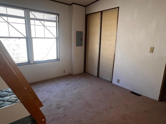 unfurnished bedroom with light carpet, a closet, and multiple windows