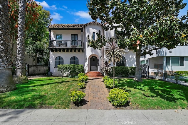 view of front facade featuring a front lawn and a balcony