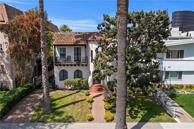 view of front facade featuring a balcony and a front lawn