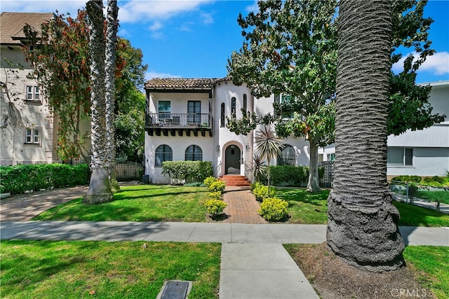 view of front facade with a front lawn and a balcony