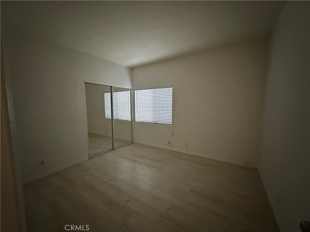 unfurnished bedroom with light hardwood / wood-style flooring and a closet