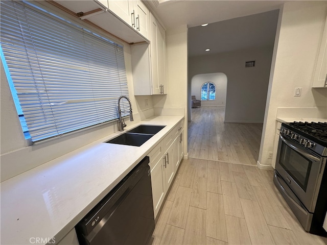 kitchen with gas range, black dishwasher, sink, and white cabinetry