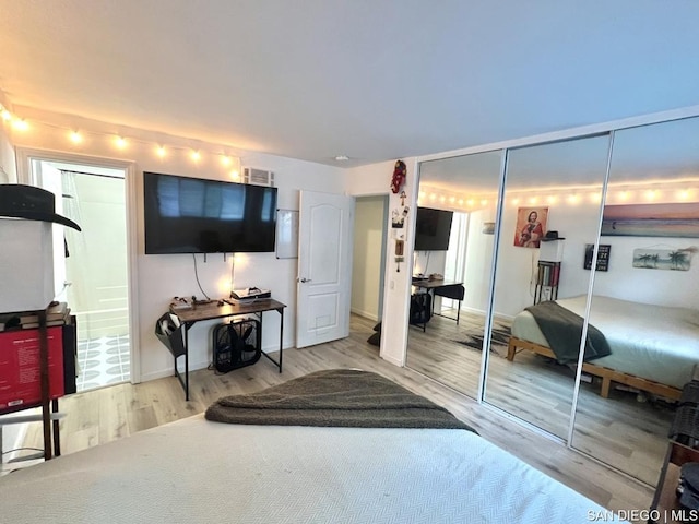 bedroom featuring hardwood / wood-style flooring, connected bathroom, and a closet