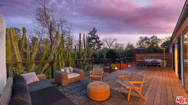 deck at dusk with an outdoor living space