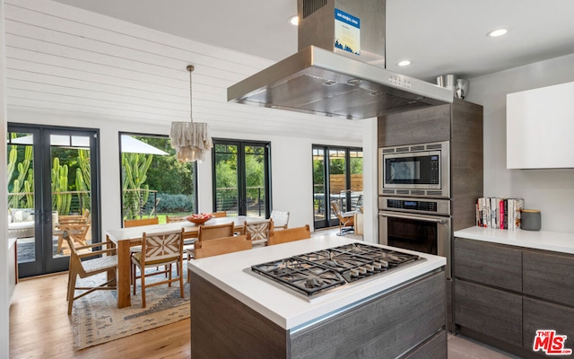 kitchen featuring appliances with stainless steel finishes, dark brown cabinets, extractor fan, and french doors